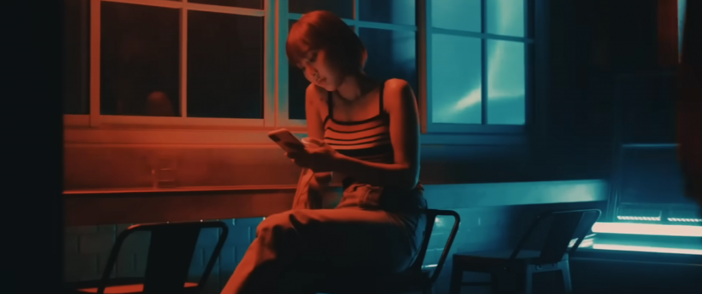 woman looking at her phone sitting in dim light
