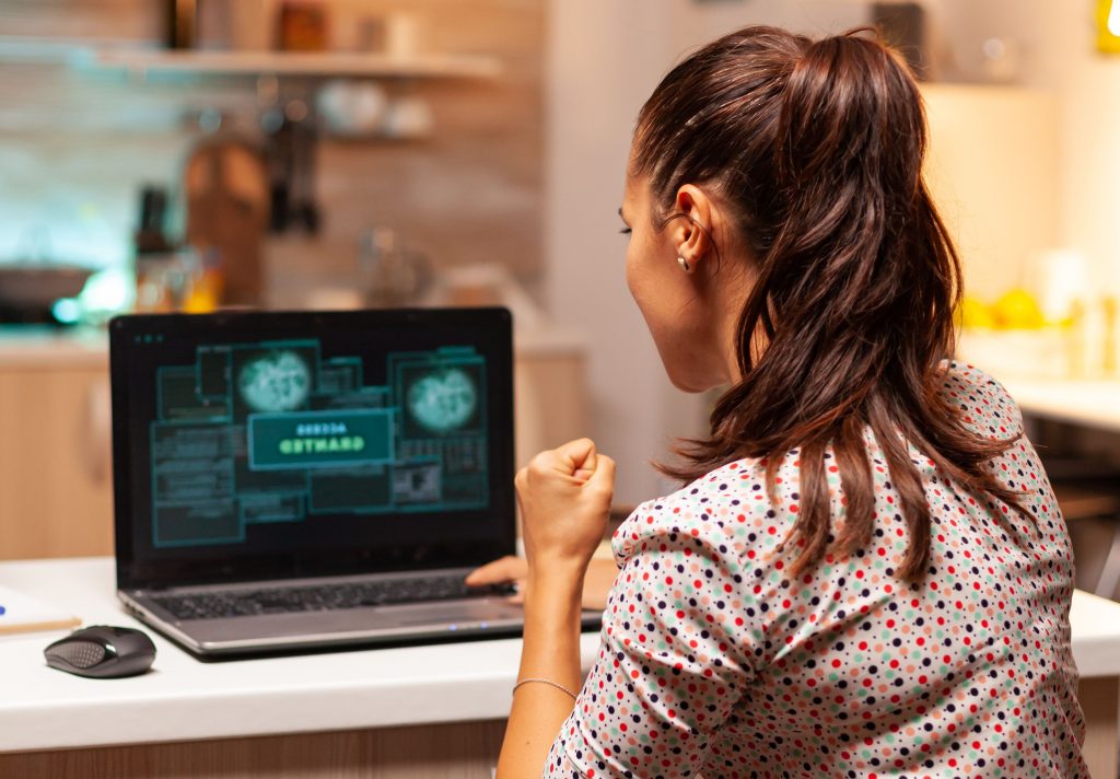 woman sitting in kitchen using mac laptop- mac antivirus