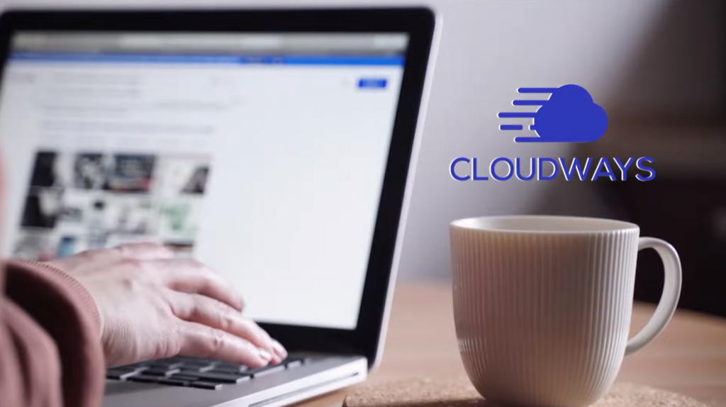 closeup of laptop with mug on a desk and ogo of cloudways