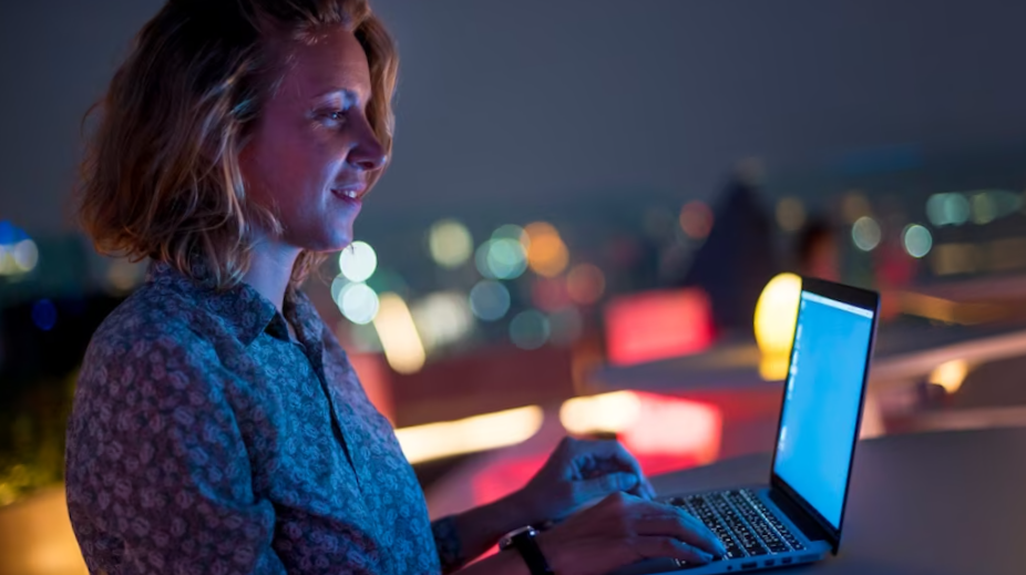 Woman using a laptop in the dark